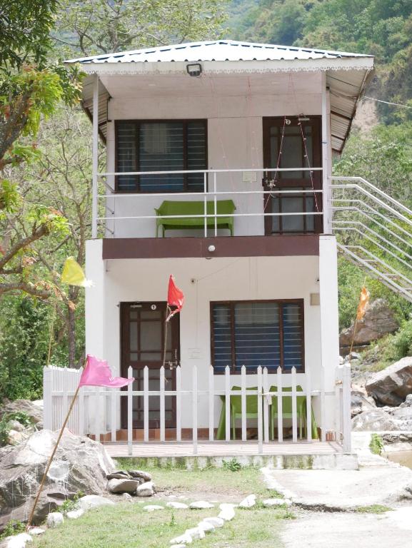 a house with a white fence in front of it at PAWSITIVE NATURE RESORT in Tehri-Garhwāl