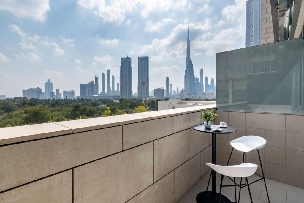 a balcony with a table and two chairs and a city skyline at Silkhaus modern studio with Burj Khalifa view in DIFC in Dubai