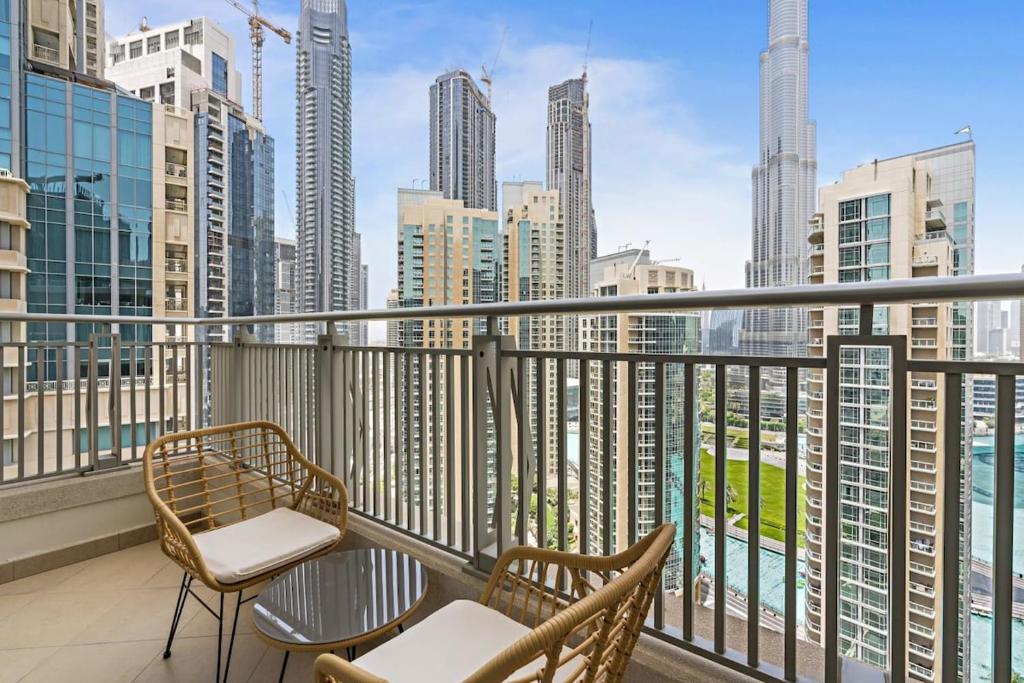 einen Balkon mit Stühlen und Stadtblick in der Unterkunft Silkhaus with full Burj Khalifa & fountain view 1BDR in Downtown in Dubai