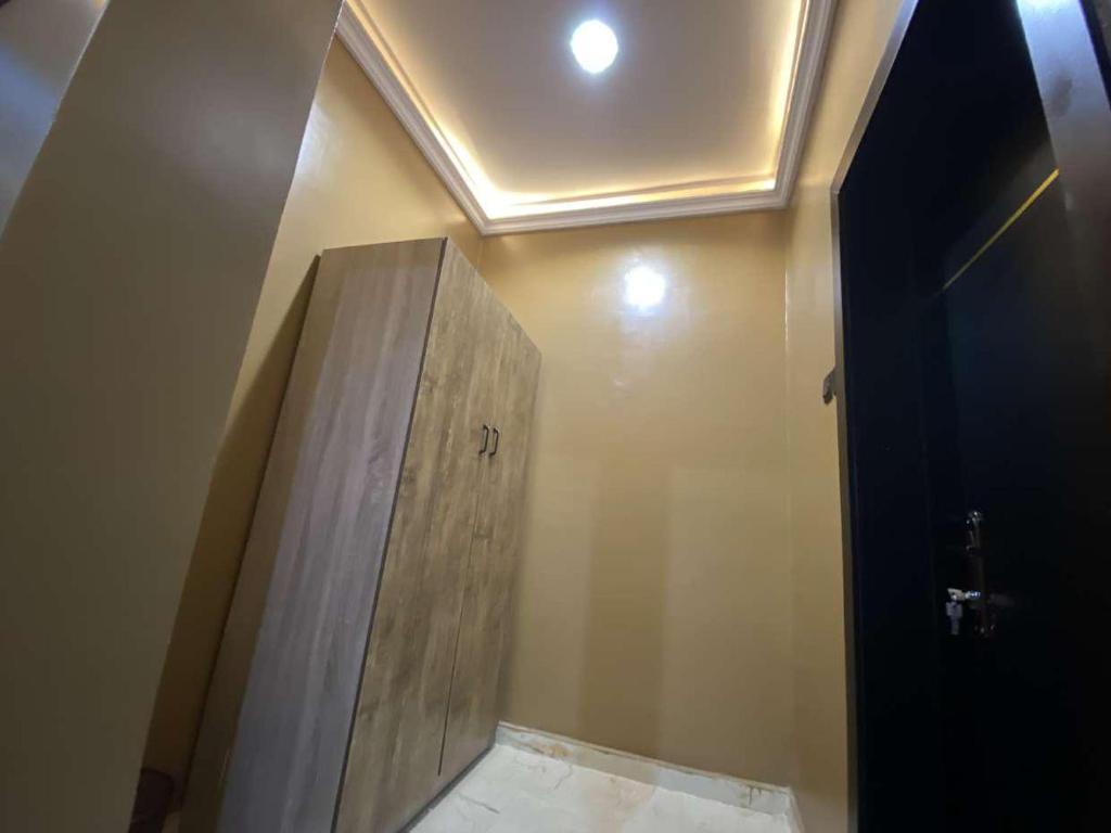 a bathroom with a wooden door on the wall at Hotel Fountain Blu in Abeokuta