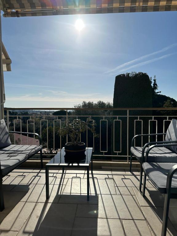 un patio avec une table et des chaises sur un balcon dans l'établissement The Place *****, à Cannes