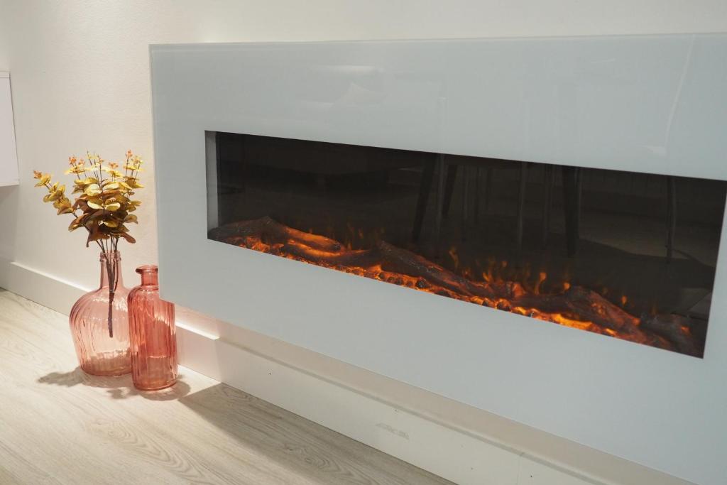 un camino con due bottiglie e un vaso con fiori di Moderno apartamento con garaje privado en el centro de Vigo a Vigo