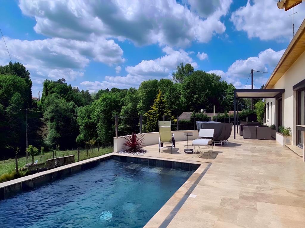 - une piscine dans une cour avec des chaises et une terrasse dans l'établissement Au Petit Bonheur, à Maurens