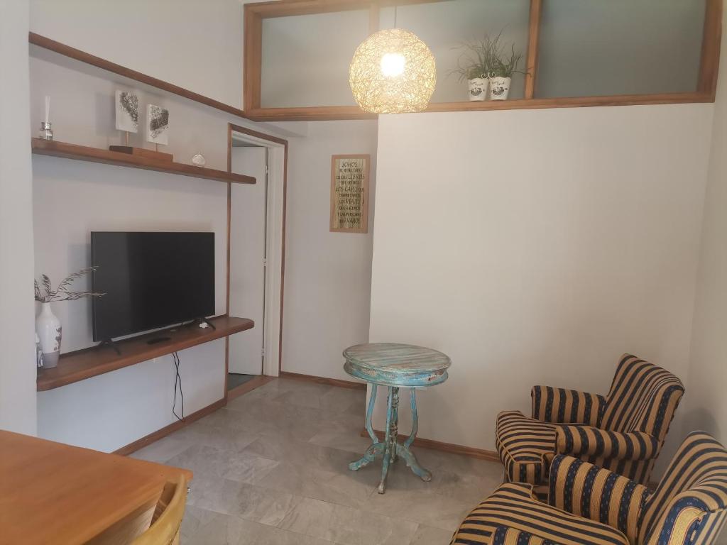 un soggiorno con 2 sedie, un tavolo e una TV di MANDALA HOME a Durazno