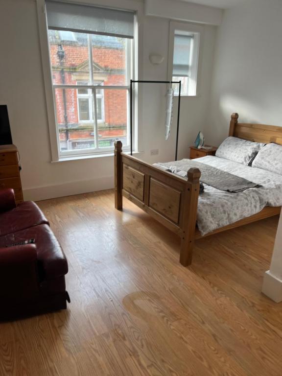 a bedroom with a bed and a large window at Aspect apartments in Chesham