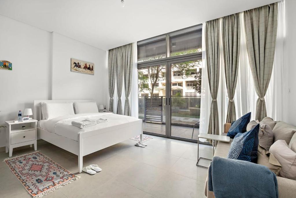 アブダビにあるSilkhaus Luxury studio in Saadiyat Islandの白いベッドルーム(白いベッド1台、ソファ付)
