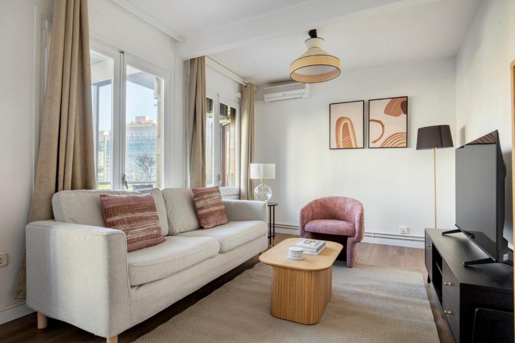 a living room with a couch and a table at Blueground Pedralbes balcony swimming pool BCN-124 in Barcelona