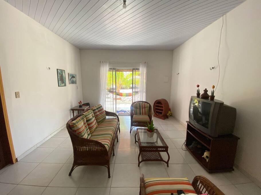 a living room with couches and a tv at Chalé de Praia - Salinopolis/Pa in Salinópolis