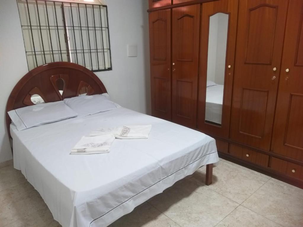 a bedroom with a bed and a cabinet and a mirror at Casa Com Piscina. Prox. Mar e Lagoa Ideal Família in Marataizes