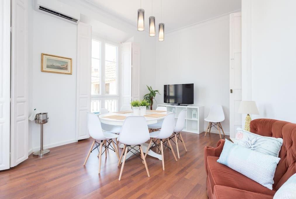 un salon avec un canapé, une table et des chaises dans l'établissement Sunny Málaga Apartments, à Malaga
