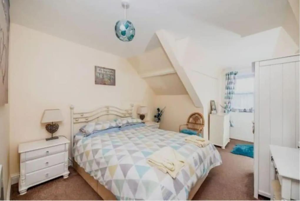 a bedroom with a large bed and a staircase at Cosy 2 Bedroom Apartment near Seafront in Penzance