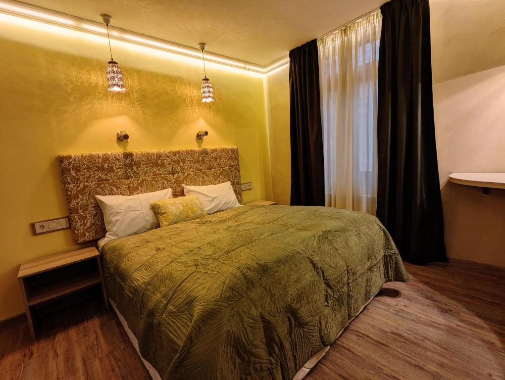 a bedroom with a large bed in a room at Покрит Мост in Lovech