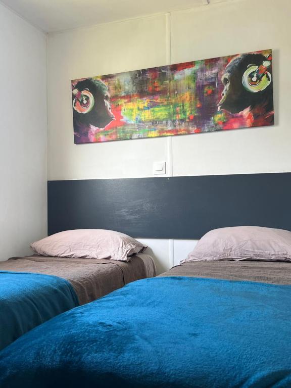 1 dormitorio con 2 camas y un cuadro en la pared en les bungalows de Lisa Maria, en SERRA DI FIUMORBO
