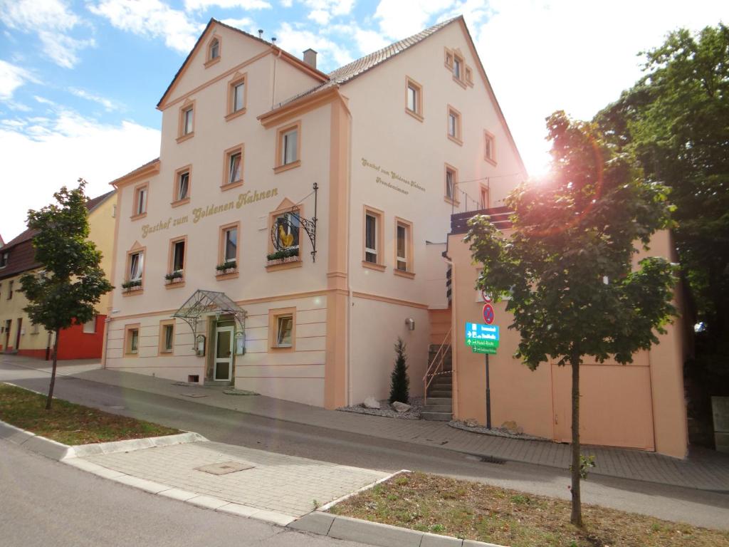 ein großes weißes Gebäude an der Straßenseite in der Unterkunft Hotel-Restaurant Zum Goldenen Hahnen in Markgröningen