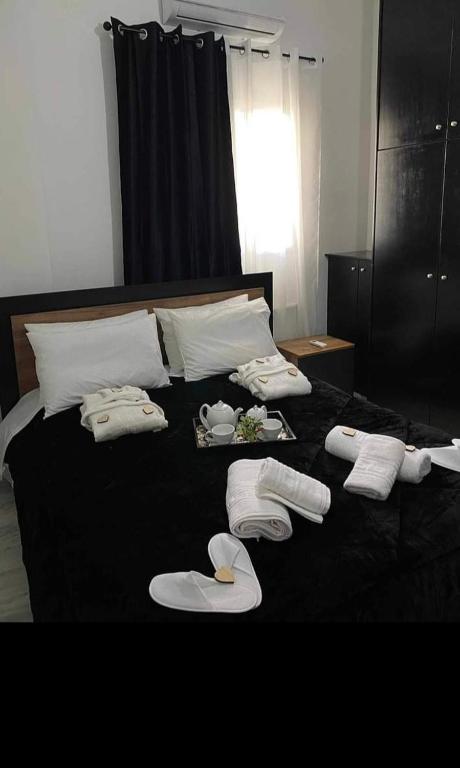 a bed with white towels and slippers on it at Mirto Luxury Appartment in Heraklio Town