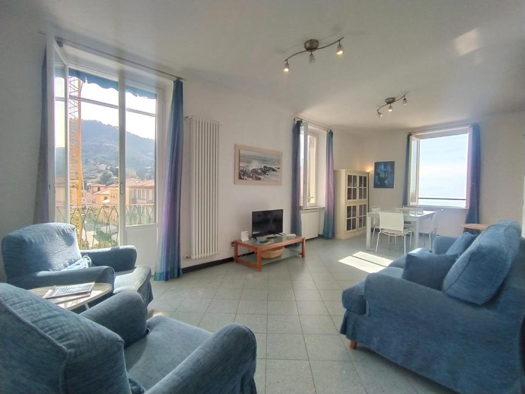 a living room with blue couches and a table at MISTRAL House in Levanto