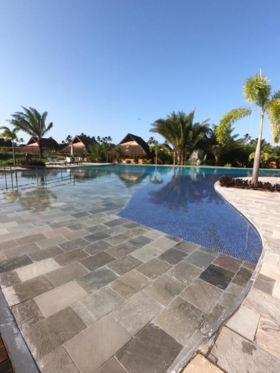 a swimming pool at a resort with palm trees at ECO RESORT PRAIA DOS CARNEIROS in Tamandaré