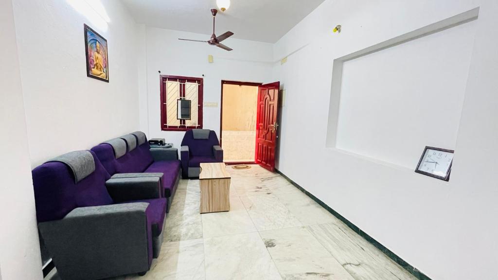 a living room with a purple couch and a table at White House - 2BHK - Esha Apartment in Coimbatore