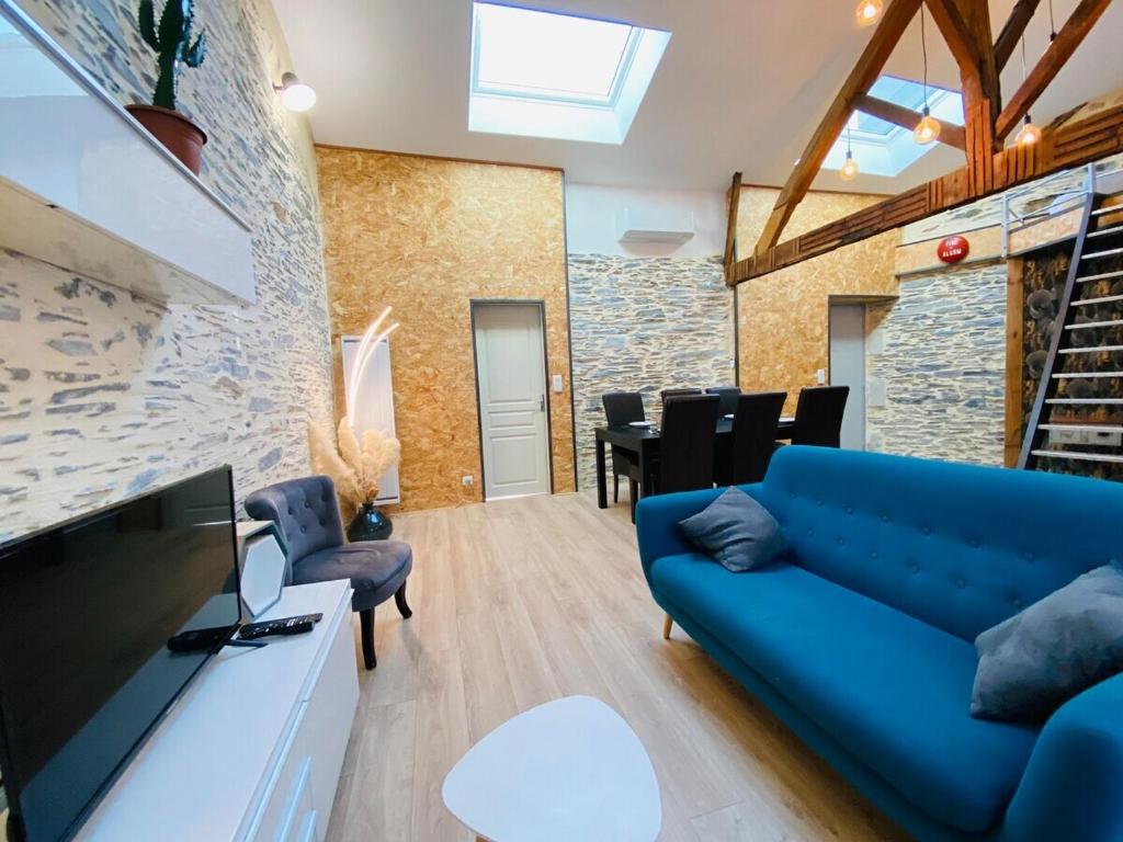 ein Wohnzimmer mit einem blauen Sofa und einem TV in der Unterkunft Casa Arena in Trélazé