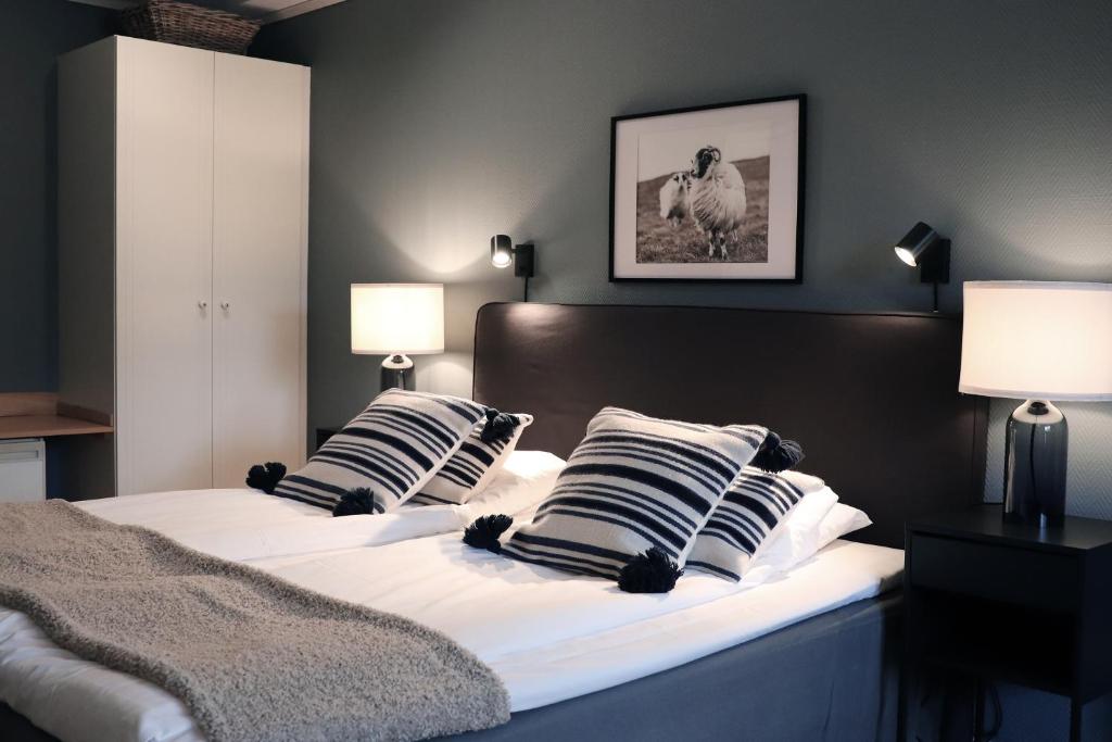 a bedroom with two beds with striped pillows at Hotell Miskarp in Mjölby