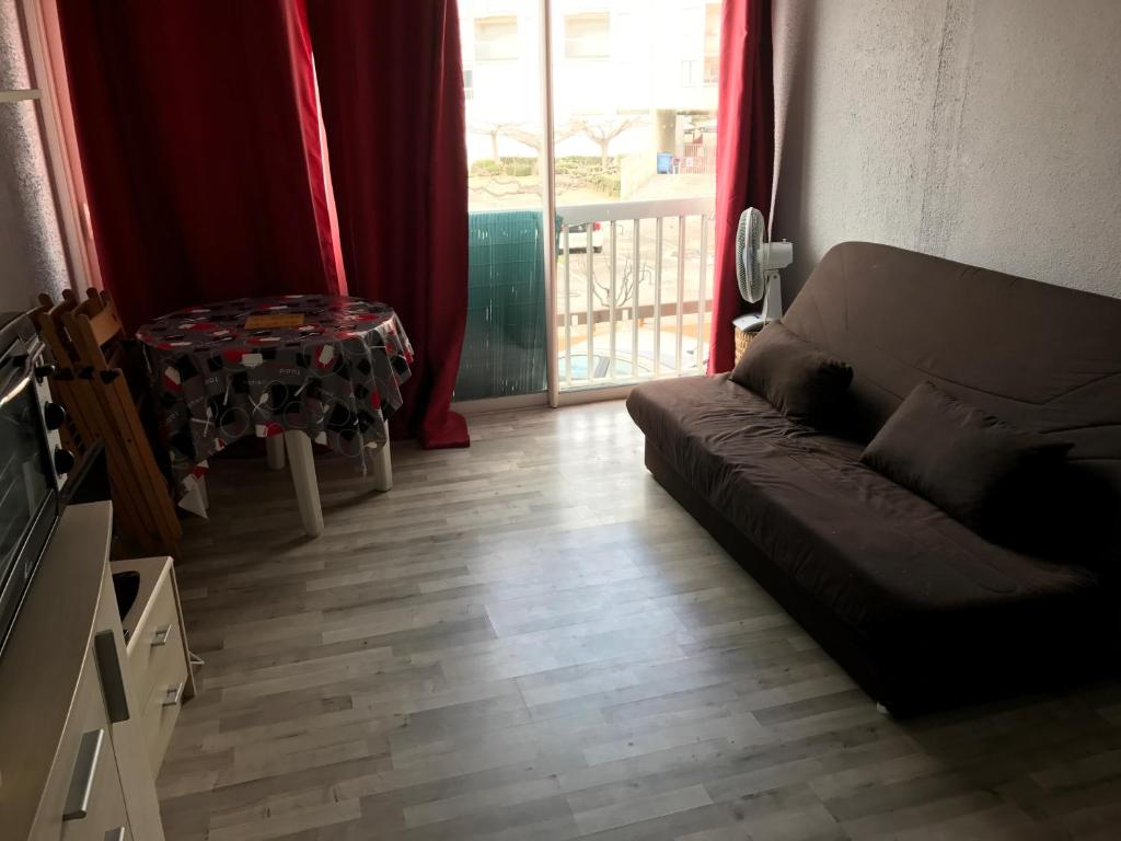 un salon avec un canapé et une table dans l'établissement Grau du Roi studio cabine 4 personnes 300 m de la plage, au Grau-du-Roi