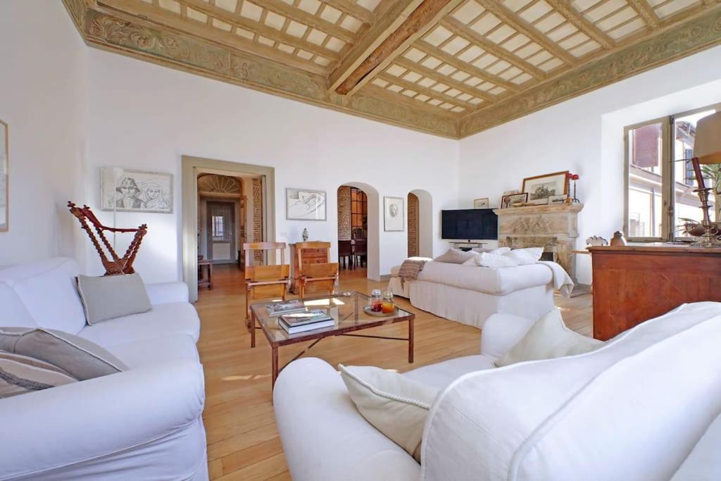 a living room with white furniture and a wooden ceiling at Piscinula in Rome