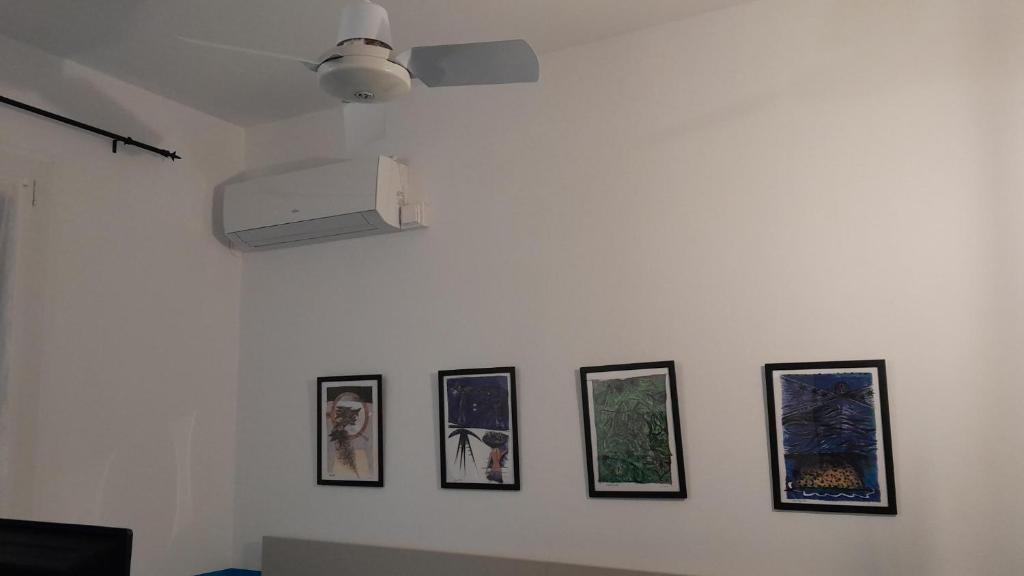 a white wall with four pictures on it at Hotel Villa Argentina in Riomaggiore