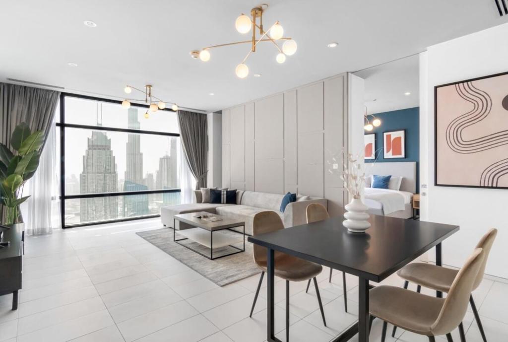a living room with a dining table and a couch at Silkhaus Index Tower 1BDR with stunning view in DIFC in Dubai