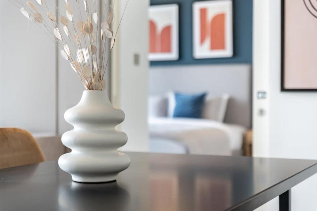 a white vase sitting on a table in a living room at Silkhaus Index Tower 1BDR with stunning view in DIFC in Dubai