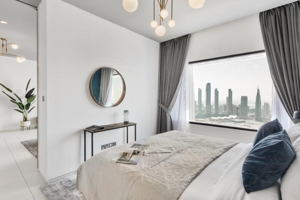 a bedroom with white walls and a large window at Silkhaus Index Tower 1BDR with stunning view in DIFC in Dubai