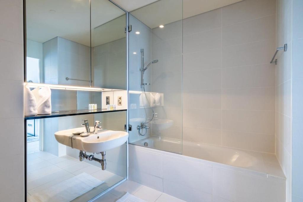 a bathroom with a sink and a shower at Silkhaus Index Tower 1BDR with stunning view in DIFC in Dubai