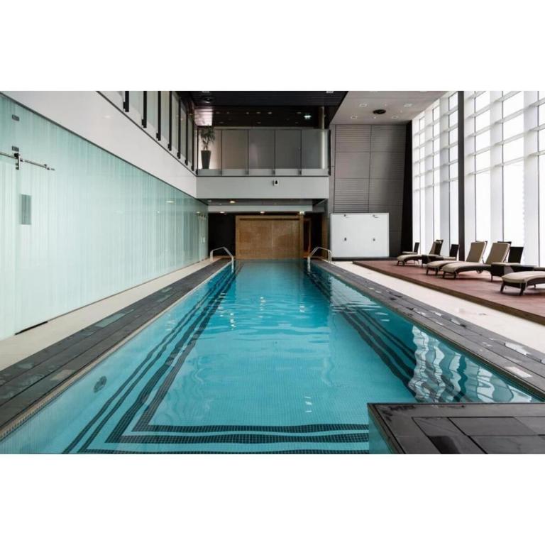 a swimming pool with blue water in a building at Silkhaus Index Tower 1BDR with stunning view in DIFC in Dubai