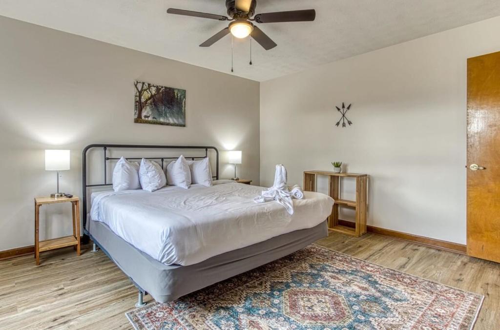 a bedroom with a white bed with a ceiling fan at Pool - Pinecrest Townhomes-1KING 2BUNK UNIT- Updated in Pigeon Forge