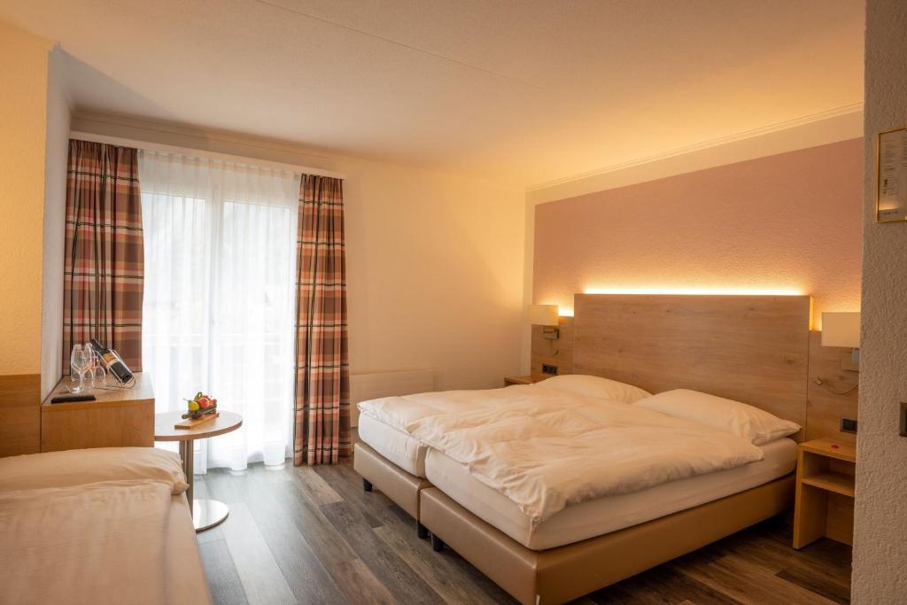 ein Schlafzimmer mit einem großen Bett und einem Fenster in der Unterkunft Hotel Brienz in Brienz