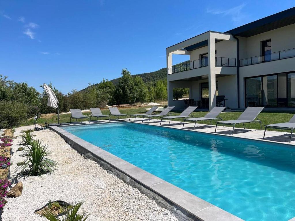a house with a swimming pool with lounge chairs at Villa de 6 chambres avec piscine privee jardin clos et wifi a Saint Peray in Saint-Péray