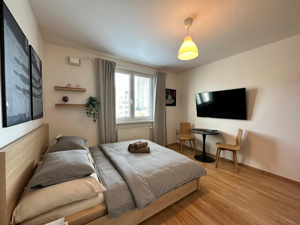 1 dormitorio con cama, mesa y TV en Cozy studio apartment in the wider center en Nivy