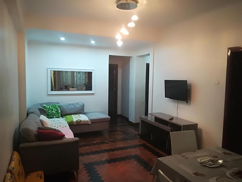 een woonkamer met een bank en een tv bij Oásis Tropical: Flat de Luxo na Beira, Moçambique in Beira