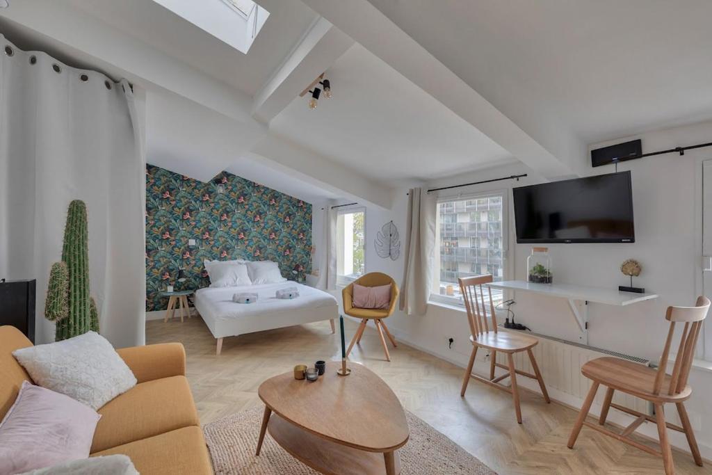 a living room with a couch and a table at Appartement Cosy proche Arc Triomphe - 2P in Paris