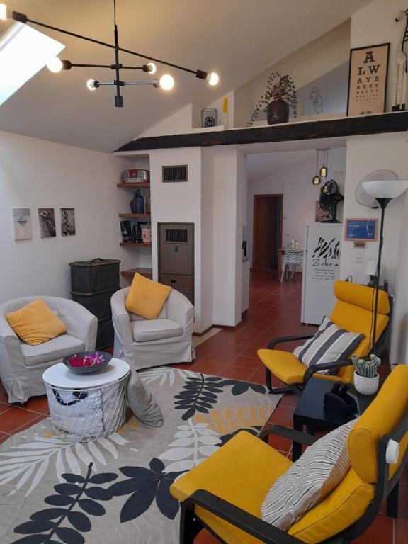 ein Wohnzimmer mit Sofas, Stühlen und einem Tisch in der Unterkunft Cèc & Evita in Roveredo