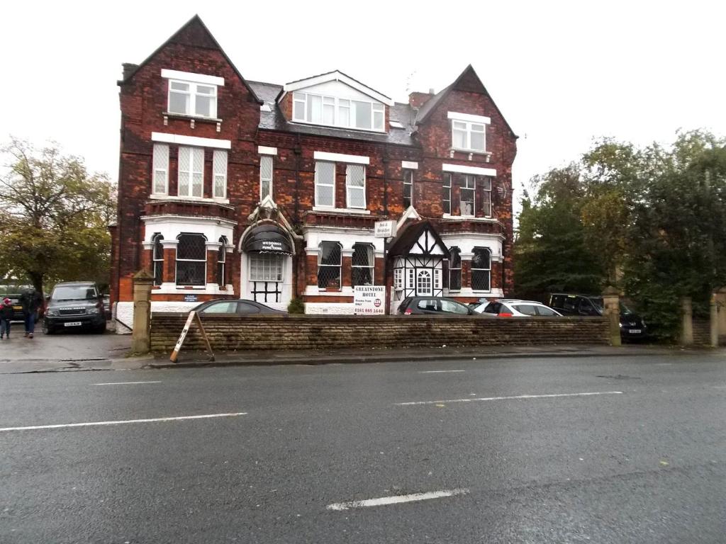 a large brick building with cars parked in front of it at Greatstone Lodge in Manchester