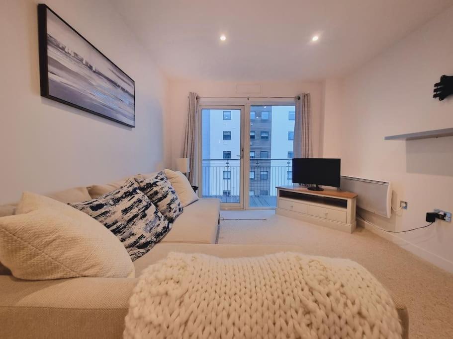 uma sala de estar com um sofá e uma televisão em Riverview Apartment em Cardiff