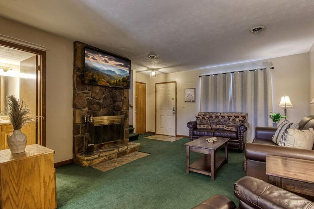 a living room with a couch and a fireplace at Pool-Pinecrest Townhomes-1King-2Queen Unit in Pigeon Forge
