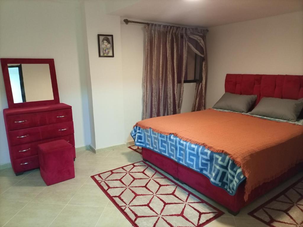 Schlafzimmer mit einem Bett, einer Kommode und einem Spiegel in der Unterkunft La petite Kasbah in Marrakesch