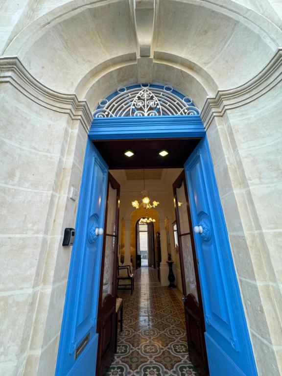 une porte bleue dans un bâtiment avec couloir dans l'établissement B&S Accommodation 1940 House of Character, à Żejtun