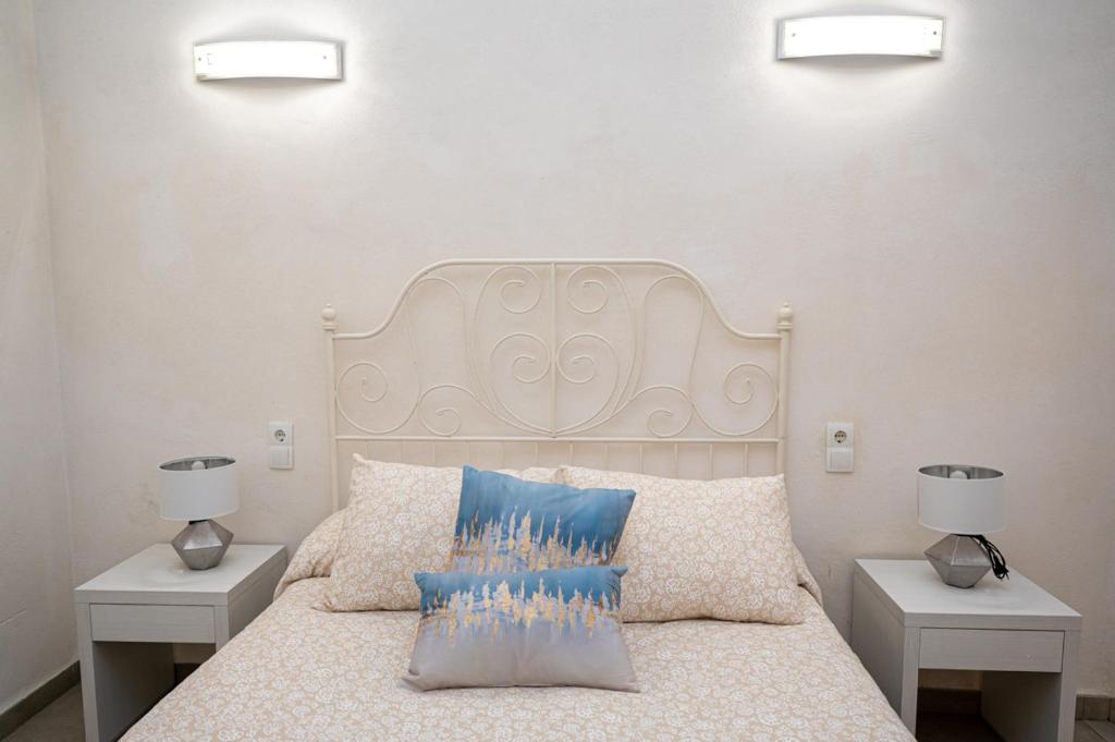 Un dormitorio con una cama blanca con dos mesitas de noche. en Villa Yasmin Blue, en Muro