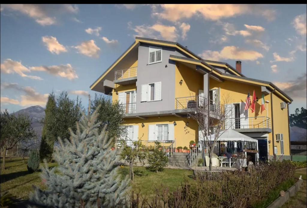 a large yellow house with a christmas tree in front of it at Hotel Villa Linda in Shkodër