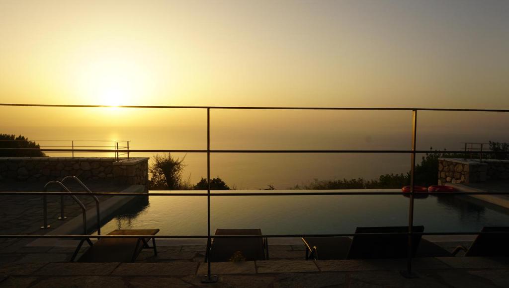 a view of a pool with the sunset in the background at Point of View Andromeda in Drymon