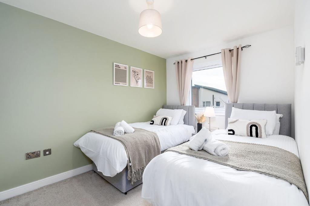 a bedroom with three beds with white sheets at 6 Guests - 3 Bedrooms - Free WI-FI - Manchester in Manchester
