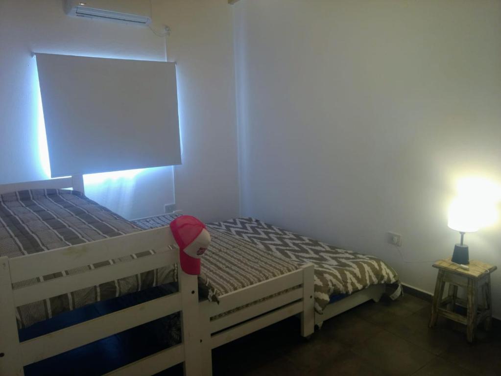 a bedroom with a wooden bed with a red hat on it at DIVINA CASITA PASO DE LA PATRIA in Paso de la Patria