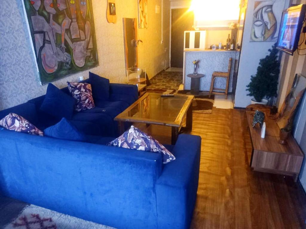 Sala de estar con sofá azul y mesa de centro en Studio prestige N1 pieds sur Mer en Rabat